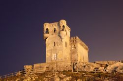 Antica torre di Tarifa illuminata di notte, Spagna. ...