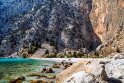 Una spiaggia di ghiaia sull'isola di Symi, Grecia. Arida, rocciosa e dura, quest'isola del Dodecaneso si trova 41 km a nord dalle coste di Rodi.
