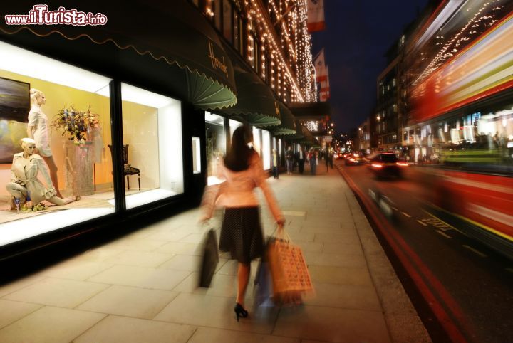 Immagine Una donna intenta nello shopping cammina davanti alle vetrine di Harrods, a Londra - © visitlondonimages / britainonview / Juliet White