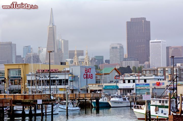 Immagine E' la San Francisco più tipica; Fisherman s Wharf con la città della California sullo sfondo  - © ChameleonsEye / Shutterstock.com