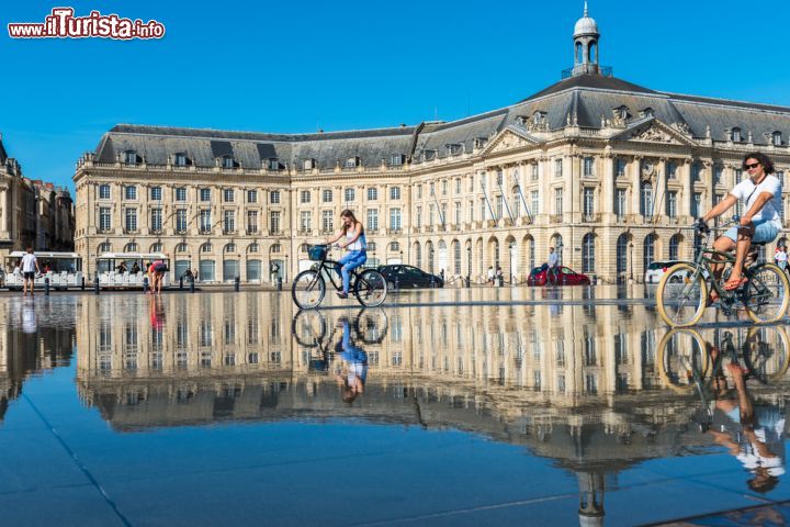 Immagine La gente ama attraversare lo Specchio d'acqua posto di fronte a Place de la Bourse anche con la bici o il monopattino. Siamo a Bordeaux, in Francia - foto © dvoevnore / Shutterstock.com