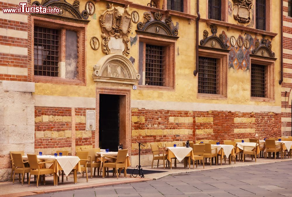Immagine I tavolini di un ristorante di fronte al Palazzo della Ragione in Piazza dei Signori a Verona, Italy