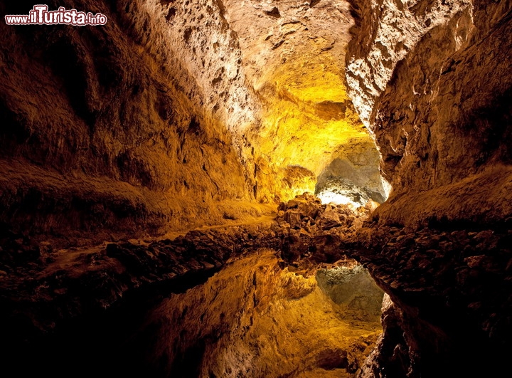 Cueva de Los Verdes, Lanzarote - Oltre al celebre Parco Nazionale di Timanfaya, l'isola di Lanzarote, la più orientale dell'arcipelago delle Canarie, possiede altri vulcani che nel corso della storia hanno prodotto numerose eruzioni. Una di questa avvenne circa 4.000 anni fa sul vulcano La Corona, sulla punta nord dell'isola, vicino alla località di Haria: la lava si è raffreddata esternamente, mentre ha continuato a fluire all'interno, che svuotandosi ha creato un tunnel naturale, la Cueva del Los Verdes, chiamata così per i minerali dalle tinte verdi delle sue pareti. E' considerato il tunnel vulcanico più largo del mondo, e per la sua ottima acustica la grotta è utilizzata anche come auditorium per dei concerti. La sua lunghezza complessiva è di circa 6 km - © Skowron / Shutterstock.com 