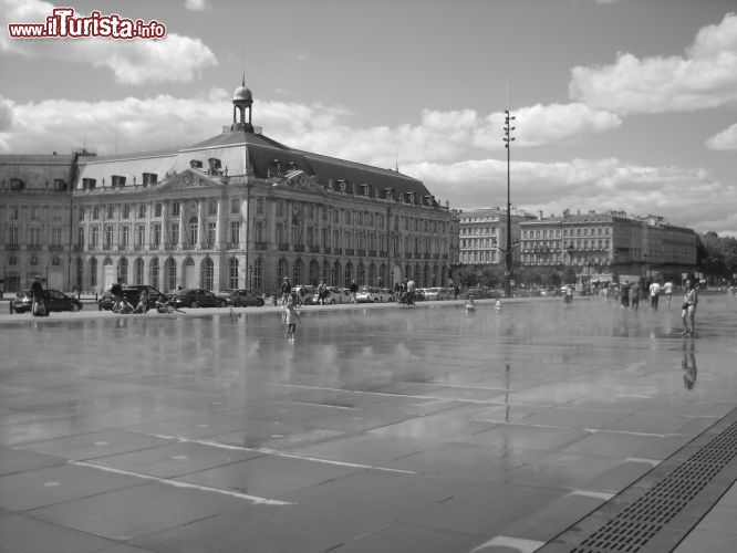 Immagine Di fronte a Place de la Bourse a Bordeaux il Comune ha creato questo specchio d'acqua di pochi centimetri di profondita dove amano giocare sia gli adulti che i bambini durante le giornate più calde.