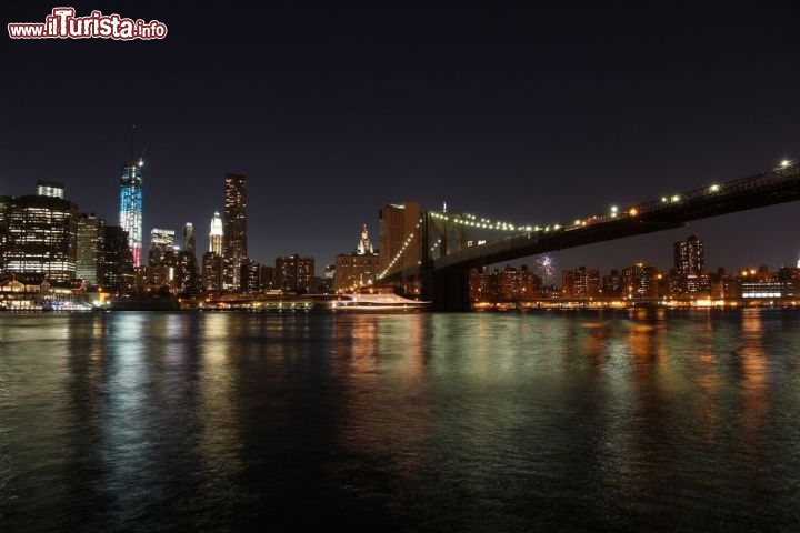 Immagine Fotografia di notte del Ponte di Brooklyn illuminato, sulla sx la Freedom Tower illuminata con i colori della bandiera americana - © Tupungato / Shutterstock.com