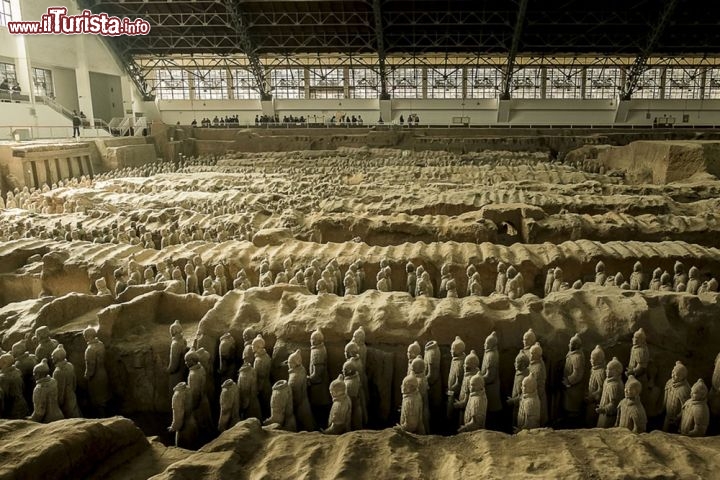 La tomba di Qin Shi Huangdi e l’esercito di terracotta, Cina
La Cina ha sempre rappresentato per gli occidentali una terra incantata, piena di tradizioni misteriose e costumi esotici. È diventata ancor più seducente dopo la scoperta del cosiddetto “esercito di terracotta”, avvenuta nel 1974 ad opera di un ignaro gruppo di contadini locali. Si trovavano vicino alla città di Xi’an, nella provincia di Shaanxi, e scavando nel terreno arido alla ricerca di acqua si imbatterono in strani frammenti di ceramica: non sapevano che, continuando lo scavo, sarebbero venute alla luce oltre 6 mila sculture di soldati, cortigiani e saltimbanchi. Qualcuno li aveva sepolti lì dopo la morte dell’imperatore Qin Shi Huangdi, che aveva regnato dal 260 al 210 a.C., perché proteggessero l’accesso orientale alla sua tomba. Oggi intorno al sito archeologico è nata una vera e propria città che vive di turismo, con alberghi, ristoranti e altre attrazioni. Sono molti i visitatori che ogni anno si recano in visita alla grande armata di terracotta dichiarata Patrimonio dell’Umanità dall’UNESCO, distribuita in 4 pozzi principali e altri vani sotterranei minori ma il cui scavo deve ancora essere completato. Ancor più misteriosa resta la tomba dell’imperatore, un enorme tumulo di terra che si estende per 57 kmq e attende di essere scavato. Sappiamo che per realizzarlo ci vollero circa 40 anni di lavoro e centinaia di migliaia di uomini, che poi vennero sepolti vivi perché non rivelassero i segreti del grande mausoleo. Perché non cominciare il disseppellimento del sepolcro e dei suoi tesori? Il Dipartimento Nazionale dei Reperti Culturali lo ha detto chiaramente: la Cina non è pronta, tecnologicamente né finanziariamente, per un’impresa del genere, che passerà in mano alle generazioni di domani.

Nel frattempo, per visitare l’esercito di terracotta, sappiate che l’aeroporto più vicino si trova a Xian Yang, una piccola città a breve distanza da Xi’an. Da lì si può raggiungere il sito archeologico in autobus o in taxi. Il sito ufficiale è unicamente in lingua cinese… ma può essere utile per guardare qualche foto o per chi si intende di mandarino. - © BigGabig / Shutterstock.com