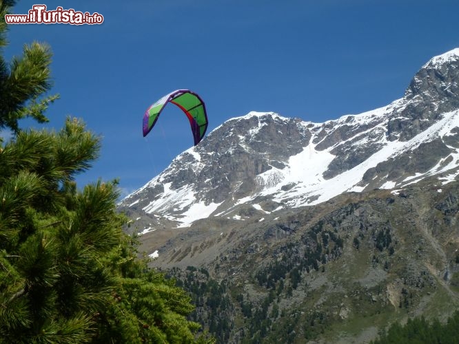 Immagine Vela di un kitesurf si staglia nel cielo di Silvaplana