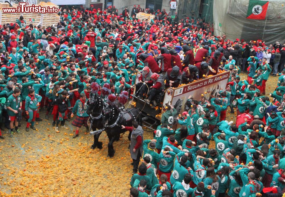 Immagine Arancieri e pubblico al carnevale di Ivrea, Piemonte. Immancabile per tanti il berretto frigio, il copricapo rosso simbolo di libertà - © Massimo Sardo / www.storicocarnevaleivrea.it