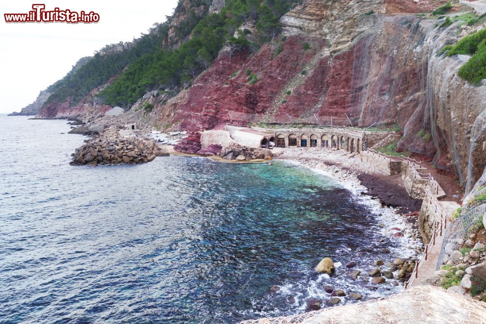 Immagine Cala Estellencs fotografata dall'alto, Maiorca, isole Baleari, Spagna. Pareti rossastre fanno da cornice all'acqua trasparente di questo angolo di Baleari.