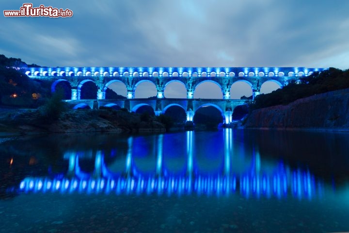 Immagine Acquedotto romano a Vers, nella Linguadoca Rossiglione: il Pont du Gard viene illuminato con delle luci colorate - © Matej Kastelic / Shutterstock.com