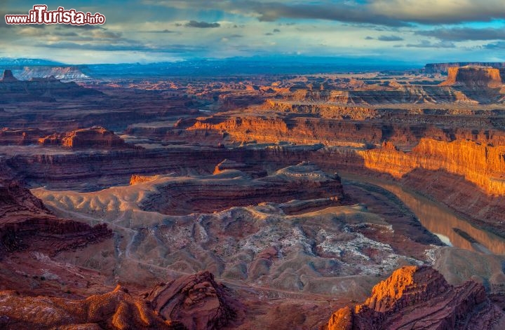 Immagine Le tinte dorate dell'alba nel Canyonlands National Park dello Utah, negli USA. Luci e giochi di ombre rendono ancora più affascinanti le pieghe del canyon, che si trasforma in un'architettura naturale fantastica. L'immagine è scattata dall'altopiano chiamato Dead Horse Point, le cui pareti di buttano a strapiombo verso il corso del Colorado - © Doug Meek / Shutterstock.com