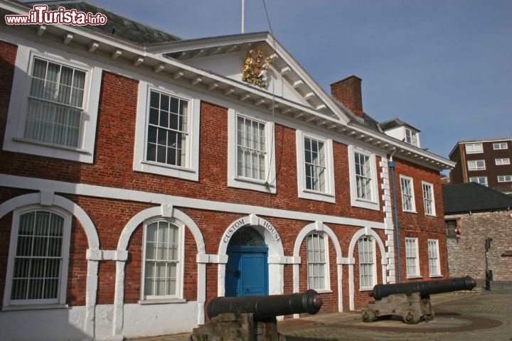 Immagine La Custom House di Exeter, Inghilterra - Passeggiando per il centro storico di questa suggestiva località del Devon, regione nel sud del Regno Unito, si possono ammirare interessanti edifici storici. Oltre al municipio Guildhall, non passa certo inosservata la Custom House, costruzione in mattoni rossi tipici della zona, che rappresenta la più antica di tutta la città. Un tempo adibito a dogana, l'edificio si trova sul molo, sede storica dei commerci lanieri, che oggi ospita pub, ristoranti e locali frequentati da turisti e visitatori provenienti da tutto il mondo © jennyt / Shutterstock.com