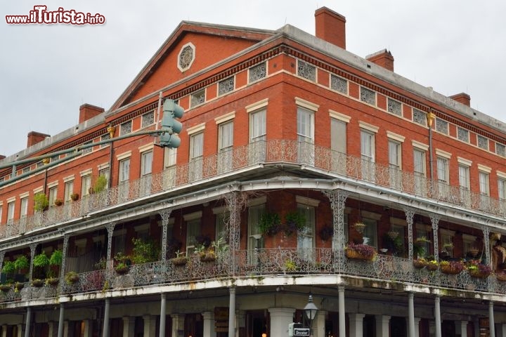 Immagine Antico palazzo del Quartiere Francese, New Orleans - In quello che è il nucleo più antico della città della Louisiana si respira un'atmosfera vivace e frizzante dove edifici e palazzi sono da sempre protagonisti indiscussi grazie a persiane in legno, balconi in ferro battuto e cortili eleganti. In questa immagine, una delle vecchie costruzioni più fotografate del French Quarter all'angolo con Bourbon Street - © gibleho / Shutterstock.com