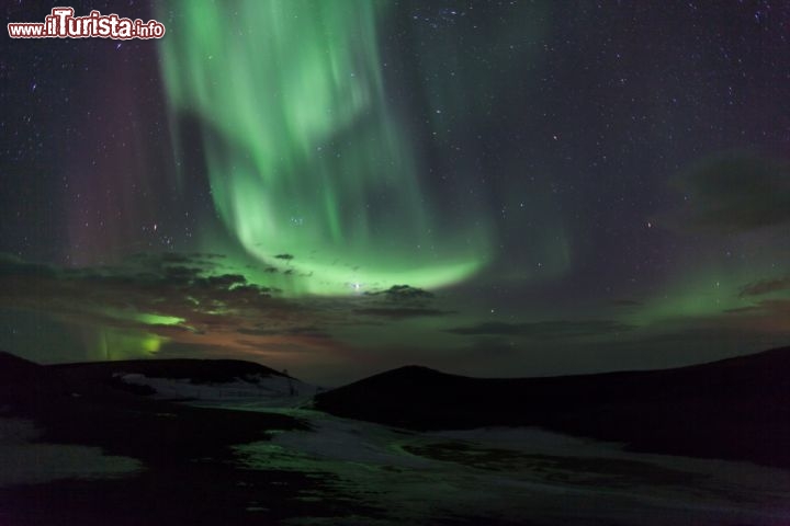 Immagine Aurora boreale in Islanda sopra a dei crateri vulcanic. L'Isalnda è una delle zone migliore del mondo per vedere l'Aurora Boreale, forse superata unicamente dal Canada e dalla Groenlandia. Da settembre a daprile qui il cielo vede spesso di notte la formazione di queste luci colorate, di verde, rosso e viola, che prendono il nome di Luci del Nord - © sharps / Shutterstock.com