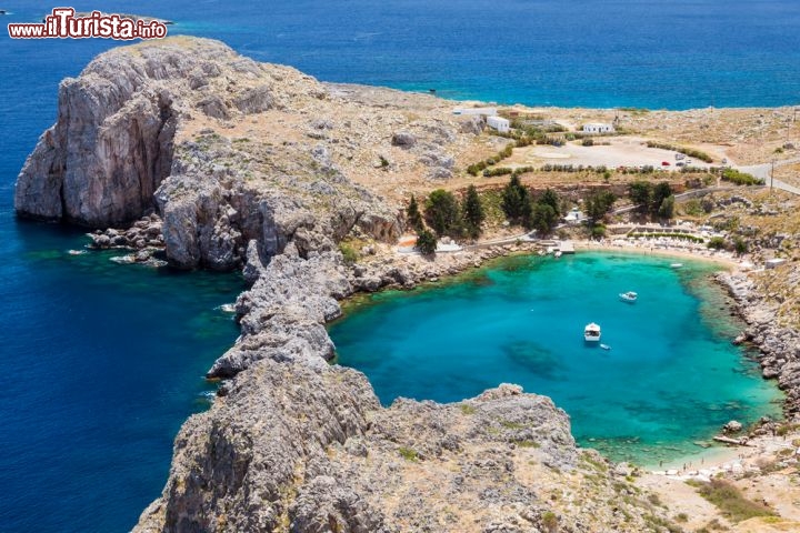 Immagine Baia di San Paolo vicino a Lindos sull'isola di Rodi - All'ombra della splendida acropoli di Lindos, la baia di San Paolo è considerata da molti come una delle più belle spiagge dell'isola di Rodi. L'acqua limpida e la sua caratteristica forma che richiama quella tipica di una piscina, trovandosi di fatto all'interno di un suggestivo porticciolo naturale, ne fanno una delle meraviglie della Grecia. Il nome è legato a doppio filo a quello di San Paolo che secondo la leggenda sarebbe approdato proprio in questo luogo nel 58 d.c. per evangelizzare gli abitanti dell'isola: in sua memoria è stata eretta una chiesetta che si affaccia direttamente sulla baia © Birute Vijeikien / Shutterstock.com