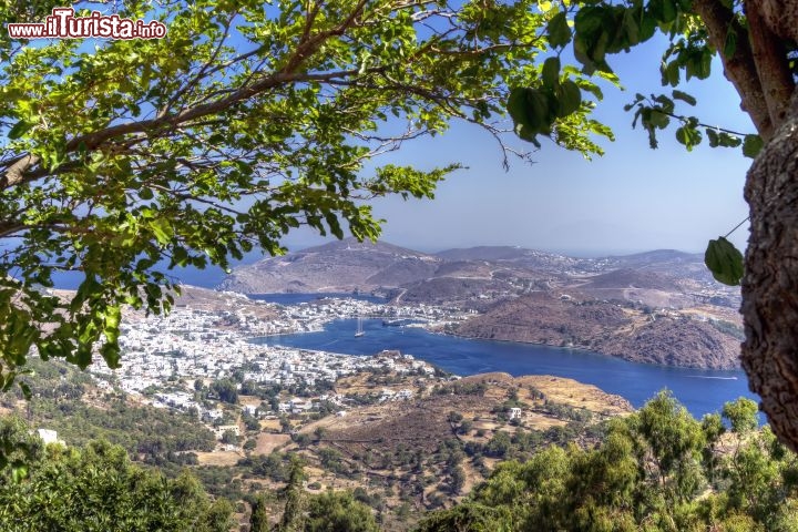 Immagine La baia di Skala a Patmos: questo magnifico angolo del Dodecaneso, in Grecia, è famoso per le sue spiagge, le case bianche dalla Chora e per il Monastero fortificato di Apokalipsis, cioè quello dedicato a San Giovanni che costodisce la grotta dove il santo ebbe la visione dell'Apocalisse e del giudizio universale - © AJancso / Shutterstock.com