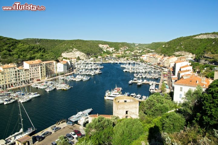 Immagine La baia e il porto di Bonifacio, in Corsica, Francia. Oltre ad essere un luogo vivace - dove si può ormeggiare la propria barca, noleggiarne una o semplicemente passeggiare lungo il molo e mangiare in qualche ristorantino - è anche il punto di imbarco dei traghetti per la Sardegna - © Bouvier Ben / Shutterstock.com