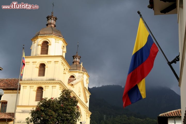 Immagine Accanto alla Cattedrale di Bogotà sventola la bandiera della Colombia. Secondo la tradizione la banda gialla (di larghezza doppia rispetto alle altre due) rappresenta l'oro del continente americano, quella blu gli oceani e quella rossa il sangue versato per ottenere l'indipendenza - © Dario Diament / Shutterstock.com