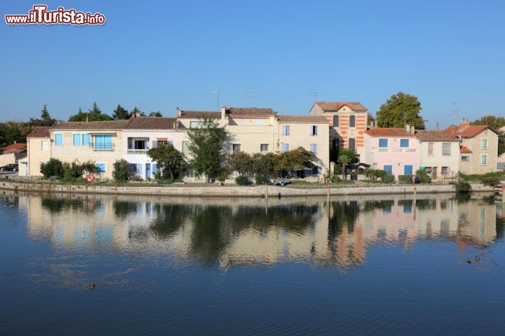 Immagine Canale e tipiche case della Camargue nei pressi di Aigues Mortes, Francia - Si riflettono sulle acque del canale le graziose e caratteristiche abitazioni della Camargue che rendono ancora più suggestiva una passeggiata alla scoperta di questo angolo di Francia © Philip Lange / Shutterstock.com