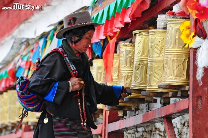 Immagine Capodanno tibetano: un pellegrino alle ruote delle preghiere presso il grande Palazzo Potala di Lhasa, in Tibet - © Hung Chung Chih / Shutterstock.com