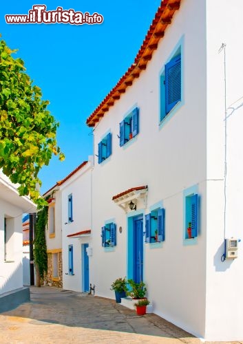 Immagine Casa greca tradizionale, bianca a  Skiathos, con le tipiche Finestre blu - © Nikos Psychogios / Shutterstock.com