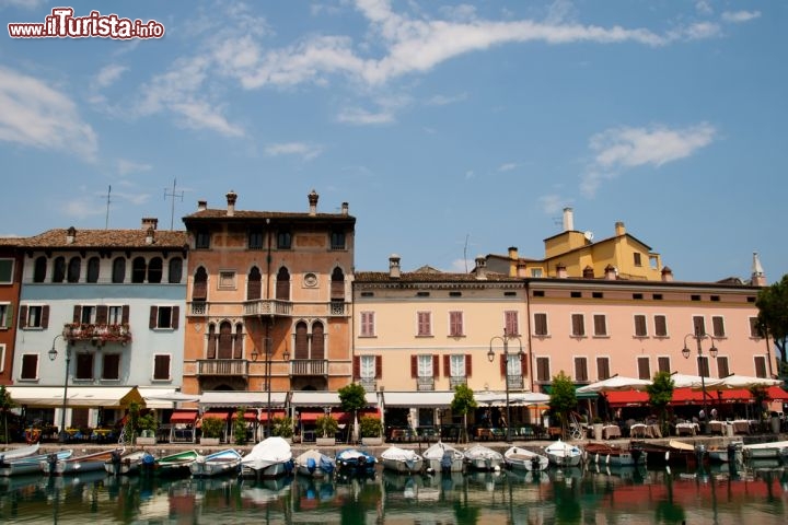 Immagine Case sul porto, Desenzano del Garda - Splendide abitazioni di impronta veneziana e napoleonica si rispecchiano nelle acque di uno dei laghi più belli d'Italia. A Desenzano, il porto vecchio costruito durante la Repubblica di Venezia rappresenta, assieme al centro storico, il cuore pulsante della città © Aigars Reinholds / Shutterstock.com