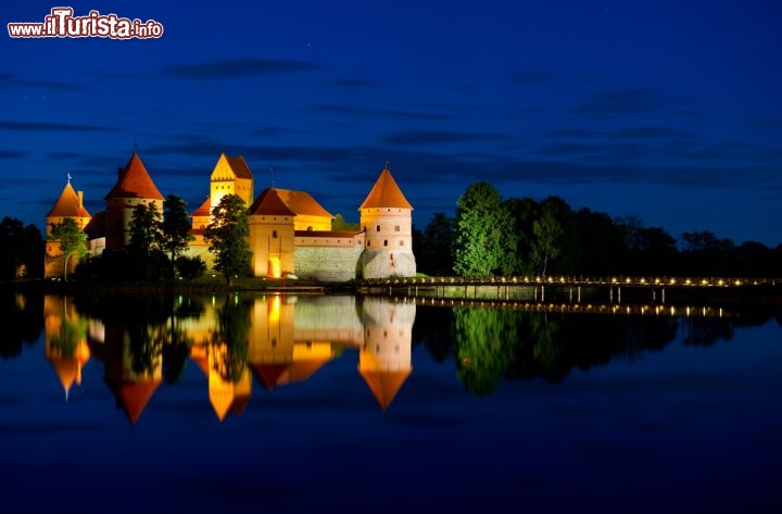 Immagine Di notte il Castello dell'isola a Trakai (Lituania) regala emozioni per i riflessi della fortezza sulle acque calme del lago Galve, trrasformandosi in un vero castello incantato - © JuliusKielaitis / Shutterstock.com