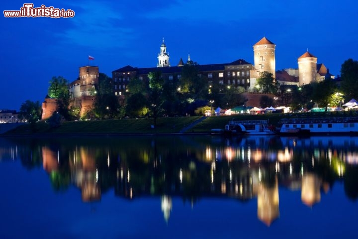 Immagine Castello di Wawel a Cracovia, di notte si riflette sulle acque del fiume Wisla della Polonia - © Iurii Konoval / Shutterstock.com