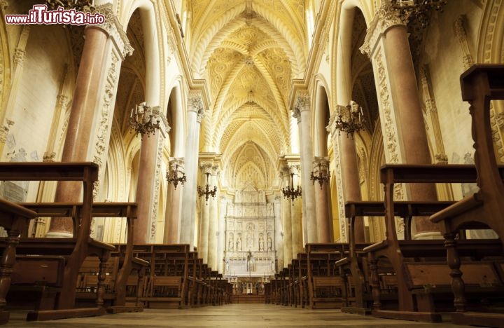 Immagine Interno della Cattedrale di Erice (Trapani, Sicilia) dedicata a Santa Maria Assunta. L'interno conservò per secoli l'aspetto originario trecentesco, con decorazioni a mosaico e una disposizione degli altari diversa da quella attuale. Fu poi fortemente modificato nell'Ottocento: oggi è a tre navate, separate da pilastri di tufo, e sull'altare principale c'è l'immagine della Madonna dell'Assunta - © Amanda Hsu / Shutterstock.com