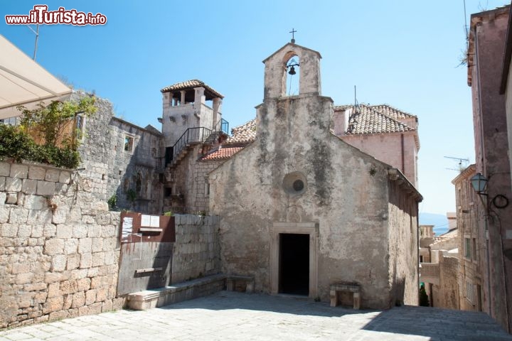 Immagine Una Chiesa Korcula e la Torre della Casa di Marco Polo in Croazia. marco polo partecipò alla battaglia di Curzola, tra veneziani e genovesi e cadde qui prigioniero. In realtà la casa di Maro Polo, che per i locali è la casa natale del grande viaggiatore, sembrerebbe un falso, e verosimilmente l'autore de il Milione è originario di Venezia e non di questa isola Dalmata, anche se nel medioeva era tutta abitata da popolazione di origine veneziana - © Aleksandar Todorovic / Shutterstock.com