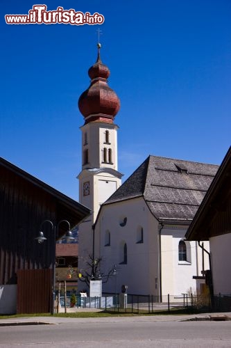 Immagine La Chiesa Tirolo situata in Alpbach, Tirolo (Austria) - Il piccolo complesso ecclesiastico che prende il nome omonimo della sua regione, si erge in tutta la sua bellezza minimale e per certi versi shabby chic. A impreziosire il suo aspetto particolarmente candido che tra l'altro si sposa benissimo con i significati liturgici della circoscrizione religiosa, è un campanile che per un dettaglio visibile nella parte finale, ricorda la maniera russa e bizantina, grazie al suo aspetto pronunciato e più eccessivo che regala nella visione d'insieme una sfiziosità in più - © LUCARELLI TEMISTOCLE / Shutterstock.com