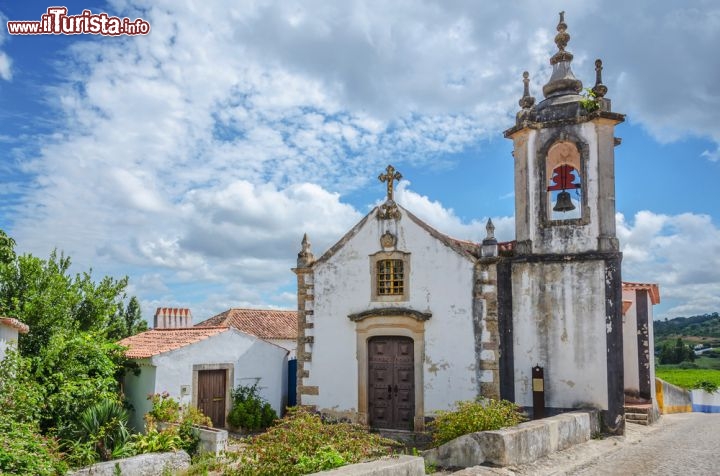 Immagine Chiesa nel centro di Obidos, Portogallo - Uno dei tanti edifici religiosi che si trovano a Obidos, famoso non solo per l'architettura sacra ma anche per quella civile. Immersa nel verde, questa graziosa chiesetta è affiancata da una torre campanaria © Chanclos / Shutterstock.com