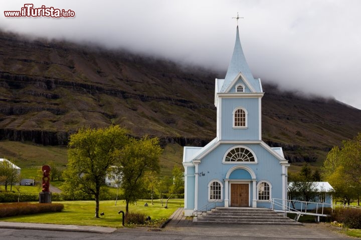 Immagine A Seydisfjordur, in Islanda, c'è una graziosa chiesa luterana detta "Chiesa blu", che con le sue pareti celesti e i dettagli bianchi sembra una casa di bambole in un paesaggio fiabesco  - © Arnold van Wijk / Shutterstock.com