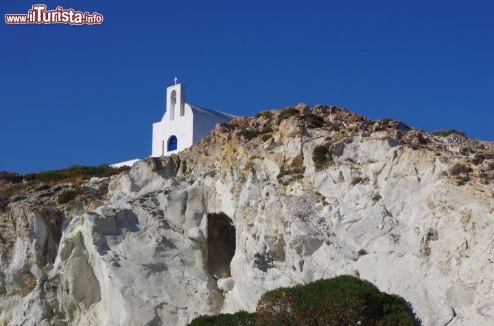 Immagine Kimolos (arcipelago delle Cicladi, Grecia sud-orientale): una chiesetta bianca contrasta col blu del cielo e la roccia nuda sopra il porto di Psathì. Il porto è a un chilometro circa da Choriò, unico centro abitato dell'isola, è accoglie le navi provenienti dal Pireo, da Lavrio e dalla vicinissima isola di Milos - © sarikosta / Shutterstock.com