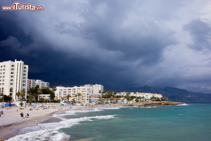 Immagine Temporale a Nerja, Andalusia - Nonostante il clima decisamente dolce di questa regione della Spagna, che vanta temperature miti e giornate di sole tutto l'anno, può capitare di imbattersi in un temporale soprattutto nei mesi primaverili e a Dicembre: il cielo assume allora tutte le tonalità del grigio e blu intenso in netto contrasto con il verde smeraldo dell'acqua del mare e il bianco delle costruzioni che si affacciano sulla spiaggia © Artur Bogacki / Shutterstock.com