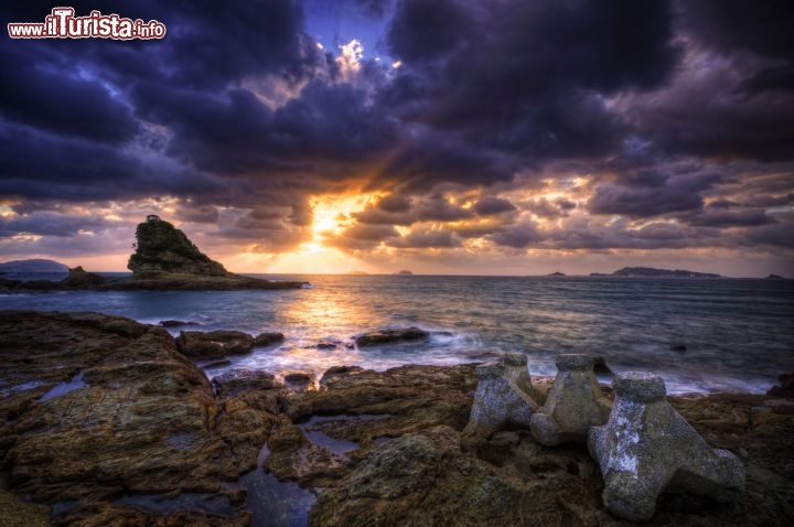 Immagine Tramonto scenografico lungo la costa di Nagasaki, Giappone, con nuvoloni plumbei trafitti dal sole - © TOMO / Shutterstock.com