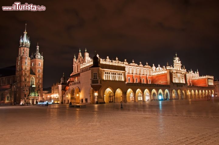 Immagine Cracovia by Night, vista notturna sulla vasta piazza del Mercato, che si apre nel cuore del centro storico della grande città della polonia, la quarta per numero di abitanti, ma la vera capitale culturale della nazione polocca - © badahos / Shutterstock.com