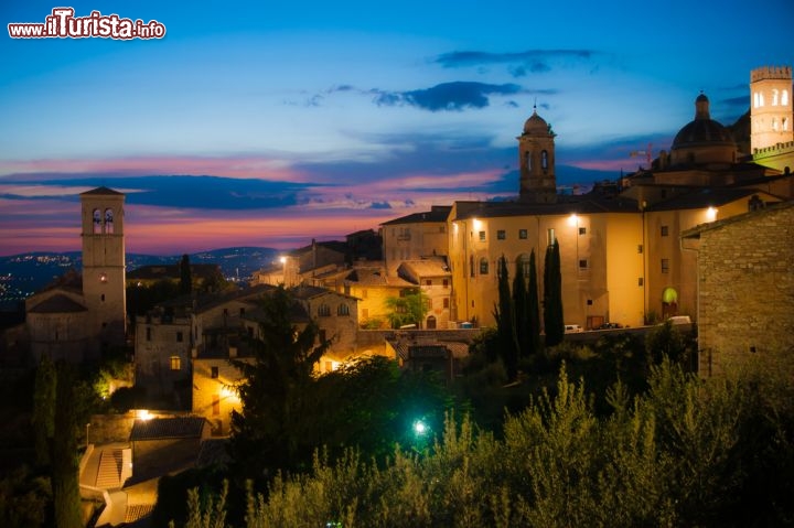 Immagine Crepuscolo sul borgo di Assisi: con le sfumature rossastre del cielo che si riflettono sulle facciate delle abitazioni e su strade e piazze, il fascino emanato dalla città umbra, che sorge alle porte di Perugia, appare ancora più forte - © Zocchi RobertoLily Zdilar / Shutterstock.com