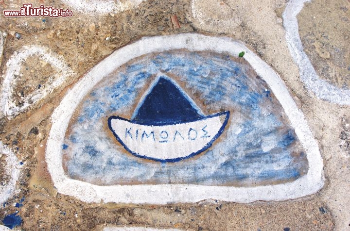 Immagine Isola di Kimolos, Cicladi, Grecia: nel centro di Choriò, unico villaggio abitato, si percorrono viottoli pittoreschi incorniciati da casette di pietra o intonaco bianco. Nell'immagine un disegno su una parete, con una barchetta e la scritta Kimolos in caratteri greci - © sarikosta / Shutterstock.com