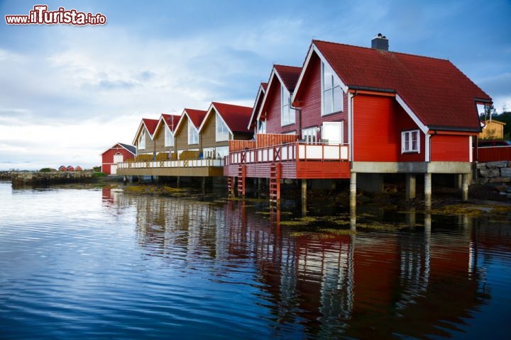 Immagine Case dei pescatori a Molde, Norvegia - Nello stemma della città sono raffigurate le due attività simbolo della città, la pesca e il legname. In epoca passata fu anche un'ambita meta turistica  tanto che Guglielmo II° vi soggiornò in diverse occasioni, soprattutto nei mesi estivi, per godere del paesaggio e del clima fresco e temperato di questo angolo di Norvegia. Ribattezzata la "Nizza del nord", Molde è attualmente un porto turistico dove attraccano navi da crociera e postali. Non c'è da stupirsi dunque nel vedere le graziose abitazioni su palafitta, tipiche dei pescatori, fare bella mostra di sè lungo la costa che si afafccia sulle acque cristalline del Mare di Norvegia © Dmitry Naumov / Shutterstock.com