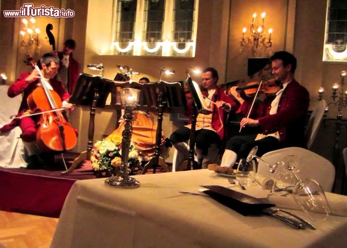 Immagine Ensenble di archi al Mozart Dinner di Salisburgo. Sono suonate dal vivo le più celebri musiche del grande Mozart: in questa immagine un gruppo di archi intenti ad allietare i commensali nel già suggestivo scenario delle sale barocche del ristorante St. Peter Stiftskeller.