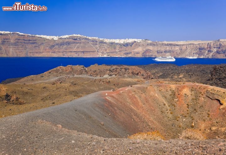 Immagine Santorini fu scossa da una Eruzione circa 3.600 anni fa, quando esplose il vulcano Paleo Kameni. Il Maremoto (Tsunami) che si generò sconvolse grande parte del mediterraneo, e creo l'isola di Santorini che aasieme a Therasia e Aspronisi forma un anello, il rofilo dell'antica caldera. Successivamente il vulcano si è riformato non distante, e nella foto vediamo l'isola di Neo Kameni teatro delle ultimi eruzioni di Santorini, e che potrebbe riprendere l'attività a breve - © Tatiana Popova / Shutterstock.com