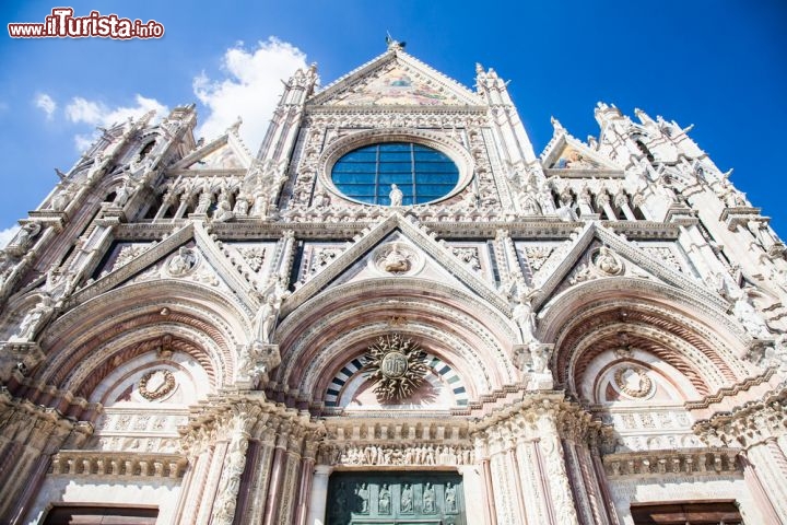 Immagine La facciata del Duomo di Siena si allunga verso il cielo con i pinnacoli e le forme appuntite tipiche del gotico toscano, ed è impreziosita dalle sculture di Giovanni Pisano (1248-1315) e dei suoi assistenti - © PerseoMedusa / Shutterstock.com