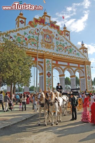 Immagine Durante la Feria de Abril, la festa più attesa di Siviglia, si balla, si mangia, si va al luna park e si ammira il maestoso passeggiare di cavalli e carrozze, con gli uomini nei loro abiti tradizionali e le fanciulle coi vestiti da flamenco. Ogni anno, per l'occasione, viene costruito un grandioso cancello d'ingresso all'area dei festeggiamenti - © SandiMako / Shutterstock.com