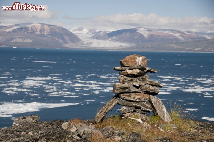 Immagine Antichissimo inukshuk dei nativi Inuit, con panorama su di un fiordo dell'Isola di Baffin nel canada settentrionale: è una delle isole più vaste del mondo, la 5a per la precisione - © City Escapes Nature Photo / Shutterstock.com