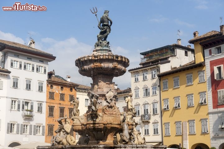 Immagine Fontana del Nettuno, Trento - Piazza Duomo ospita nel luogo esatto in cui si collocava la macchina dei fuochi in onore della festa del patrono San Vigilio la famosa fontana del Nettuno, opera dello scultore Francesco Antonio Giongo che la realizzò fra il 1767 e il 1769. All'epoca a caratterizzare questa statua fu il sofisticato sistema ideato da Giongo che permise di ottenere uno scorrimento dell'acqua continuo e senza interruzioni. Rimossa dalla fontana l'originale statuta nel 1939, ne venne poi collocata una copia in bronzo del Davide Rigatti al termine della seconda guerra mondiale, nel giorno di Natale del 1945 © Claudio Giovanni Colombo / Shutterstock.com