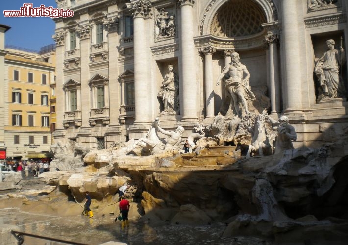 Immagine La Fontana di Trevi è uno dei simboli di Roma, immortalata da Fellini ne "La dolce vita", fotografata ogni anno da milioni di turisti e custode di un'infinità di monete lanciate come portafortuna: non è solo la più grande fontana della capitale, ma è una delle più famose al mondo. Inaugurata nel 1735, fu progettata da Nicola Salvi in perfetto stile barocco. Nell'immagine la vasca è senz'acqua per il recupero delle monete.