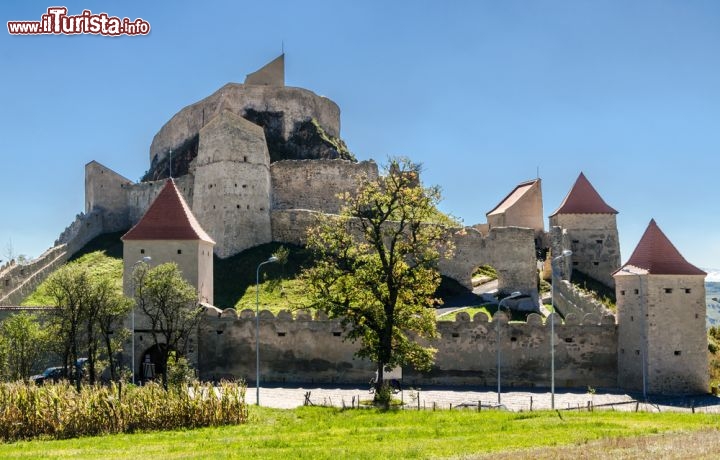 Immagine Panorama sulla fortezza di Rupea, Romania - Anticamente chiamata Castrum Kuholom in riferimento alla rocca di basalto su cui venne costruita, la fortezza di Rupea era all'epoca un posto di rifugio dei sassoni che nel 1324 si ribellarono al re ungherese Carlo Roberto di Angiò. E' formata da tre complessi architettonici: la fortezza alta costruita fra XIII e XIV secolo, quella centrale che risale al XV secolo e poi ampliata nel secolo successivo e quella bassa che è invece del XVII secolo. Riaperta al pubblico nel settembre del 2013 dopo diversi interventi di ristrutturazione eseguiti grazie a finanziamenti erogati dall'Unione Europea, la fortezza di Rupea è stata visitata da oltre 26 mila persone a testimonianza che l'eredità dei sassoni della Transilvania interessa alle generazioni attuali © David Ionut / Shutterstock.com