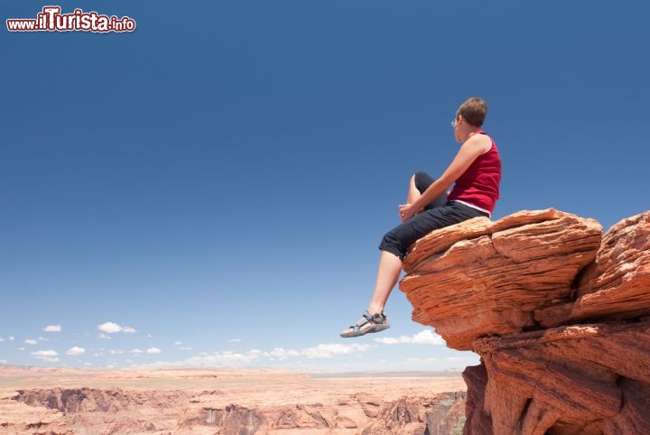 Immagine Foto di una turista sul bordo del precipizio del Grand Canyon, che si trova in Arizona (Usa) - © T-Design / Shutterstock.com