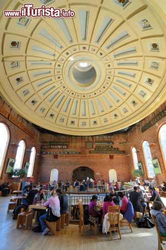 Immagine L'interno del Quincy Market di Boston, storica area commerciale situata accanto al porto, di fronte a Fenuil Hall. L'edificio, in stile neoclassico, è pieno di bancarelle gastronomiche e offre ghiottonerie e intrattenimenti di ogni genere - © SeanPavonePhoto / Shutterstock.com